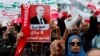 FILE - People carry banners and flags during a rally in support of Tunisian President Kais Saied in Tunis, Tunisia, May 8, 2022.