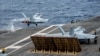 美国海军公布的这张拍摄于南中国海的照片显示，F/A-18F超级大黄蜂战斗机在“里根号”航母上起飞。(2022年7月13日)