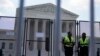 Kek Polisye kanpe devan yon kloti ki pwoteje Kou Siprem nan kom mezi sekirite, Lendi 13 Jyen 2022 nan Washington. 