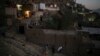 FILE - Afghans carry supplies to their home at dusk in Kabul, Afghanistan, Sept. 14, 2021. 