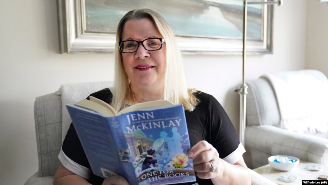 Kelly Vaiman is a great fan of cozy mysteries. They helped her deal with sorrow during the pandemic. Here she reads a cozy in her living room in Boynton Beach, Florida, February 19, 2021. (AP Photo/Wilfredo Lee)