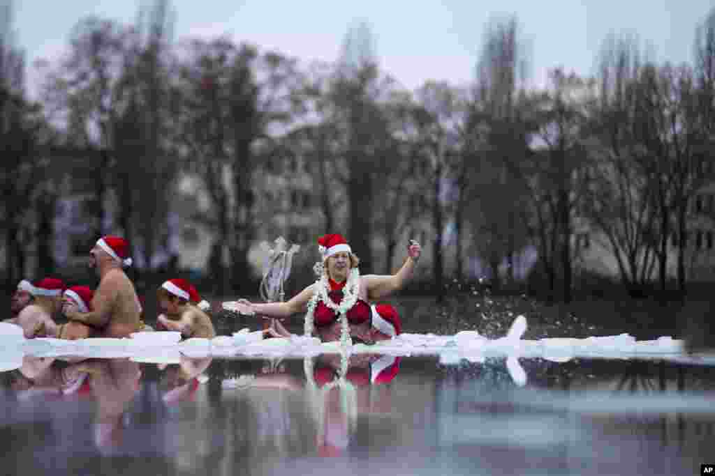 12月25日,柏林海豹冬泳俱樂部的成員在德國柏林部分結了冰的奧蘭克湖參加一年一度的聖誕游泳活動