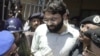 FILE - Pakistani police escort Ahmed Omar Saeed Sheikh, who was convicted in the 2002 killing of American journalist Daniel Pearl, as he exits a court in Karachi, Pakistan, March 29, 2002.