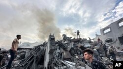 Palestinianos procuram por sobreviventes depois de um ataque aéreo no campo de refugiados de Nusseirat, Gaza Strip, 31 outubro 2023