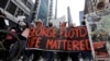 People hold signs as they march during a protest over the death of George Floyd, in Chicago, Illinois, May 30, 2020. 