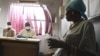 Pinky Molefe, right, gets TB medication at a clinic in Alexandra township, north of Johannesburg. (file)