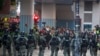 Riot police stand guard as lawyer and newly elected district councillor arrive at the Polytechnic University to meet the left-over protesters in Hong Kong, Nov. 25, 2019. 