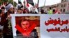 Protesters hold a poster showing Iraq's Prime Minister-designate Mohammed Tawfiq Allawi with Arabic that reads, "Rejected by order of the people," during a rally in Baghdad, Iraq, March 1, 2020.