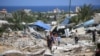 Pessoas procuram objectos recuperáveis após um ataque israelita na área de al-Mawasi em Rafah, no sul da Faixa de Gaza, em 29 de junho de 2024, no meio do conflito em curso entre Israel e o movimento militante palestiniano Hamas.