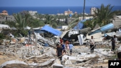Pessoas procuram objectos recuperáveis após um ataque israelita na área de al-Mawasi em Rafah, no sul da Faixa de Gaza, em 29 de junho de 2024, no meio do conflito em curso entre Israel e o movimento militante palestiniano Hamas.