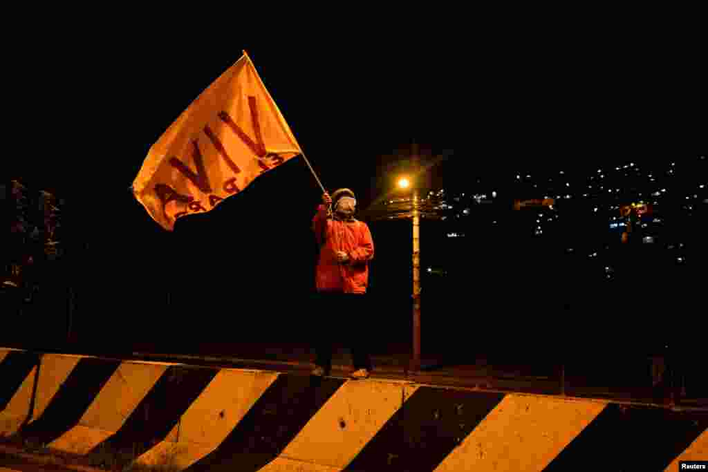 Un manifestante ecuatoriano ondea una bandera que dice "Viva el paro". 