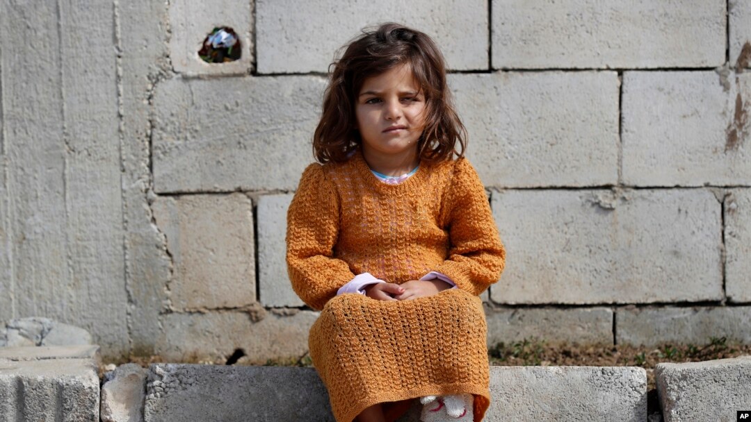Una niña siria desplazada se sienta fuera de la tienda de campaña de su familia en un campo de refugiados en Bar Elias, Valle de Bekaa, el Líbano, el 5 de marzo de 2021.