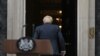 Britain's Prime Minister Boris Johnson walks back into 10 Downing Street in central London after making a statement. Johnson quit as Conservative party leader after three tumultuous years in charge.