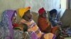 FILE - African women waiting for medical care.