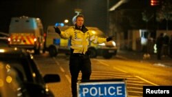 British police officers cordon off a road near a residence in Ascot, a town 40 kilometers west of London, Saturday, Mar. 23, 2013.