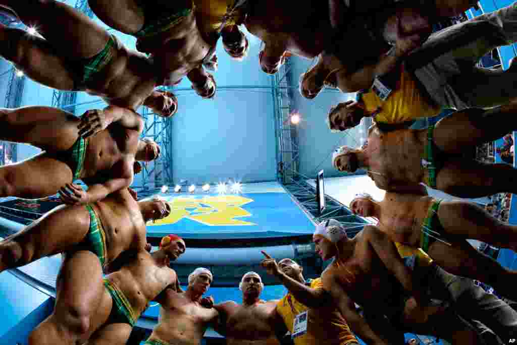 Australia's coach John Fox, pointing finger at bottom center right, talks to his players before a men's quarterfinal water polo match against Serbia.