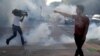Un manifestante discute con un policía mientras un reportero dispar de gas lacrimógeno durante una manifestación contra la muerte de George Floyd, en Saint Paul, Minnesota.