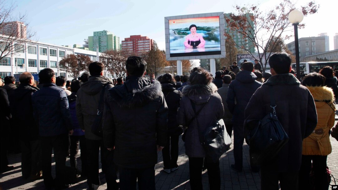 29일 평양 기차역에서 북한 주민들이 화성-15 미사일 발사에 관한 정부 성명을 대형스크린으로 시청하고 있다.