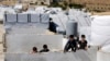 Syrian refugees children climb a concrete wall at a refugee camp in the eastern Lebanese border town of Arsal, Lebanon, Aug. 5, 2019. 