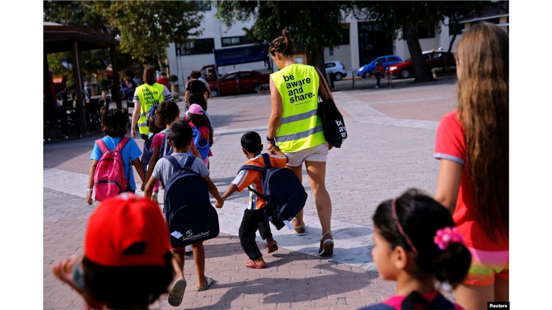 Volunteers escort refugee children at the volunteer-run "Refugee Education Chios" school on the island of Chios, Greece, Sept. 7, 2016.