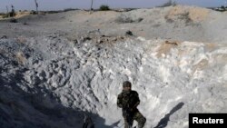 以色列軍方星期天空襲加沙地帶﹐巴勒斯坦激進分子檢視被以色列火箭空襲擊中處。