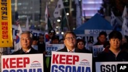 South Koreans hold banners during a rally to demand to keep the General Security of Military Intelligence Agreement, or GSOMIA, near the Foreign Ministry in Seoul, South Korea, Nov. 22, 2019.