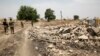 Soldiers walk among the ruins of the Government Secondary School in Chibok, Nigeria, March 25, 2016.