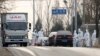 FILE - Workers disinfect passing vehicles in an area experiencing an African swine fever outbreak on the outskirts of Beijing, China, Nov. 23, 2018. 