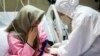 FILE - a medic wearing protective gear treats a patient infected with the new coronavirus, at Baqiyatallah Al'Azam Hospital affiliated to the Revolutionary Guard, in Tehran, Iran. 
