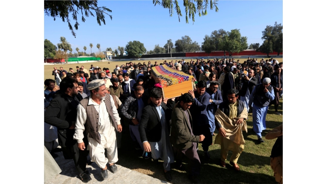 FILE - Afghan men carry the coffin of journalist Malalai Maiwand, who was shot and killed by unknown gunmen in Jalalabad, Afghanistan, Dec. 10, 2020.