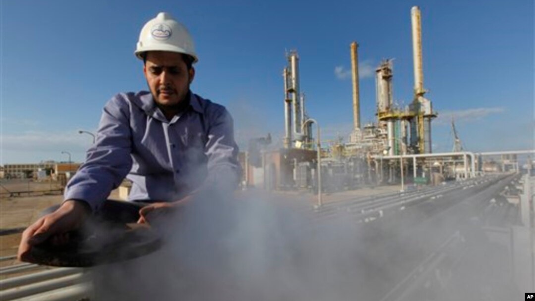 FILE - In this photo from February 2011, an employee works at an oil refinery in eastern Libya. 