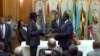 FILE - In this image made from video, South Sudan's President Salva Kiir, center left, and rebel leader Riek Machar, center right, exchange the signed documents in Addis Ababa, Ethiopia, May 9, 2014. 