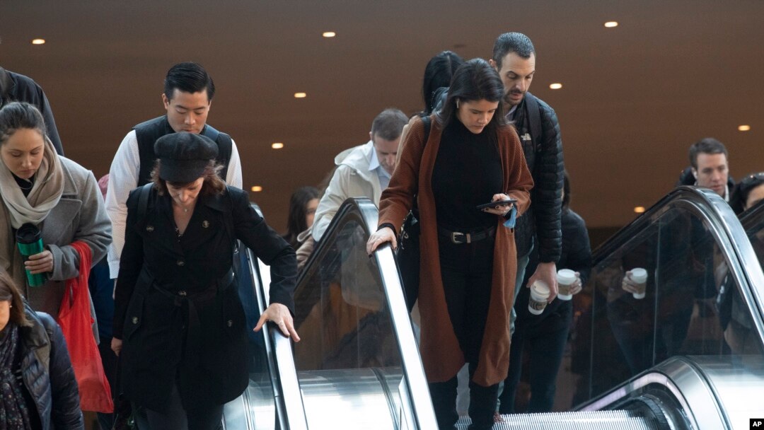 Personas se sostienen de los pasamanos de las escaleras mecánicas en el World Trade Center, el miércoles 4 de marzo de 2020 en Nueva York.