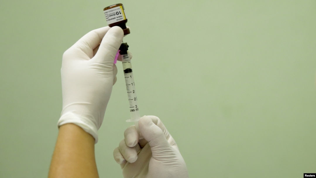 FILE - A health agent prepares a vaccine during a campaign of vaccination against yellow fever in Rio de Janeiro, Brazil, March 25, 2017.