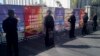 FILE - Policemen in riot gear guard a checkpoint near a courthouse where ethnic Uighur academic Ilham Tohti's trial is taking place in Urumqi, Xinjiang Uighur Autonomous Region, Sept. 17, 2014.