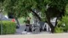 FILE - Police appear to setup a remotely operated robot during a stand off in Hutchins, Texas, June 13, 2015