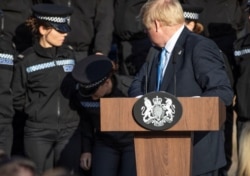 FILE - Britain's Prime Minister Boris Johnson reacts after student officer needed to sit down as he made a speech during a visit to West Yorkshire, Britain Sept. 5, 2019.