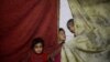 Children stand near curtains in a shelter in the besieged town of Douma, eastern Ghouta, in Damascus, Syria, March 11, 2018. 