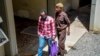 Tanzanian journalist Erick Kabendera (L) leaves the prison where he had been held for several months on Feb. 24, 2019 in Tanzania, freed after pleading guilty to economic crimes. 