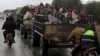 People sit in a truck with their belongings in the north east of Afrin, Syria, March 15, 2018. 