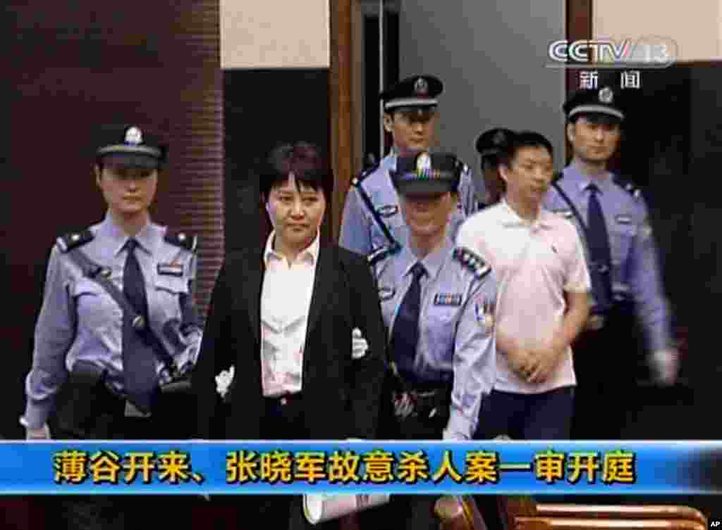 中央電視台播放的畫面顯示垮台的中國政治人物薄熙來的妻子谷開來和薄家勤務人員張曉軍被帶入中國東部的合肥市中級人民法院,他們被控害死了英國商人海伍德(2012年8月9日)。