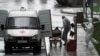 FILE - Medical personnel wearing protective gear move what appears to be a bag containing a human body, outside a hospital for coronavirus patients, on the outskirts of Moscow, Russia, May 12, 2020.