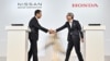 แฟ้ม - ผู้บริหารนิสสันและฮอนด้า จับมือกับระหว่างการแถลงข่าวร่วม เมื่อ 1 ส.ค. 2024 (Photo by Richard A. Brooks / AFP)