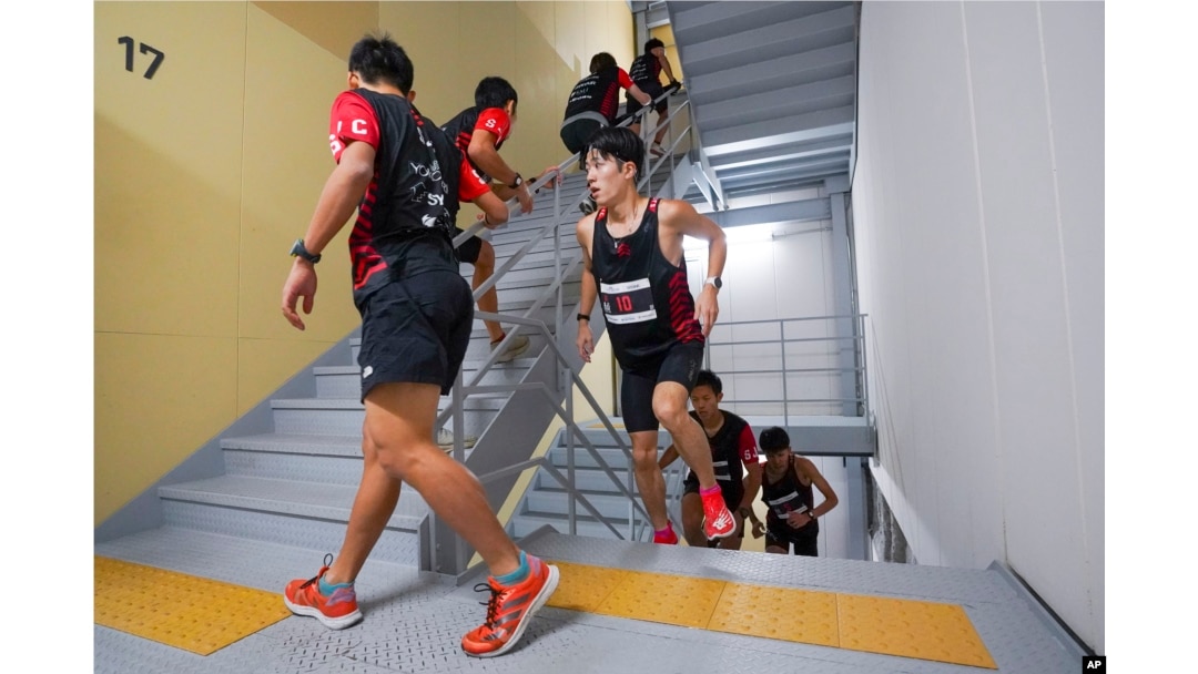 FILE - In this photo provided by ISF/Meeting, competitors climb stairs during a race of Stairclimbing World Championships in Osaka, western Japan, on Nov. 19, 2023. (ISF/MEETING via AP)
