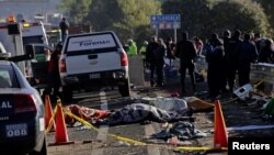 FILE - Police officers and rescue personnel stand near the bodies of people who were killed in a car crash on the outskirts of Puebla, Mexico, Dec. 12, 2017.