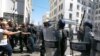 FILE - Demonstrators face police officers as they march in the streets in support of the Hirak pro-democracy movement, in Algiers, May 7, 2021.