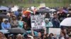 FILE - A person holds a sign that reads "Fund Climate Change Research - Saving the Planet Is Not a Waste of Money" during the March for Science in Washington, April 22, 2017.