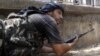 A Free Syrian Army fighter takes up his position during clashes in Aleppo, August 16, 2012.
