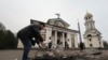 FILE - A man clears rubble in front of St. Andrew's Cathedral, which was damaged by a Russian strike on Zaporizhzhia, Ukraine, Jan. 18, 2025.