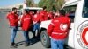 Staff from the Syrian Arab Red Crescent get ready to accompany a convoy of humanitarian aid as it waits in front of the United Nations Relief and Works Agency (UNRWA) offices before making their way into the government besieged rebel-held towns of Madaya, Zabadani and Moadimayet al-Sham in the Damascus countryside, as part of a U.N.-sponsored aid operation, in Damascus, Syria, Feb. 17, 2016.
